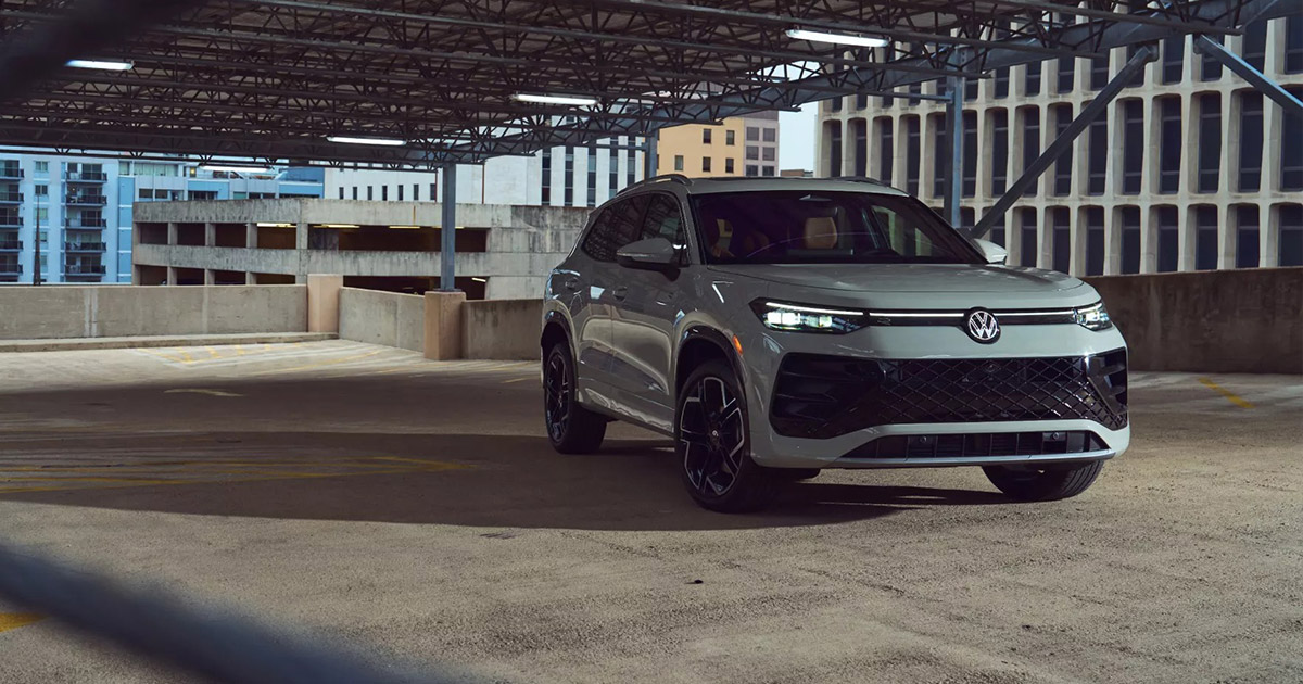 Silver Volkswagen SUV parked in urban concrete parking structure, sleek design with black accents and modern styling