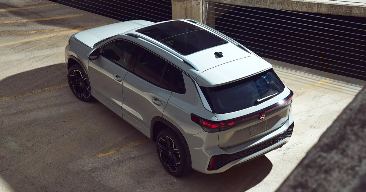 2024 Volkswagen ID.4 electric SUV in white, parked in modern concrete garage with sleek design and black wheels