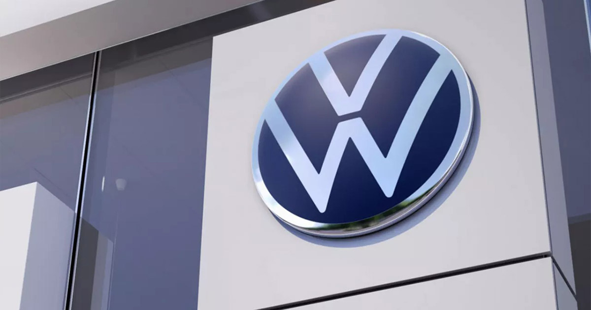 Volkswagen logo on a dealership building, metallic blue and white circular emblem mounted on white wall