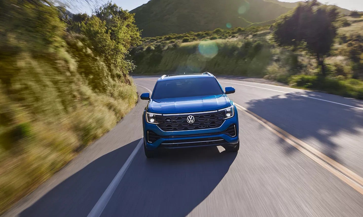 Blue Volkswagen Atlas-Cross-Sport in motion on the road