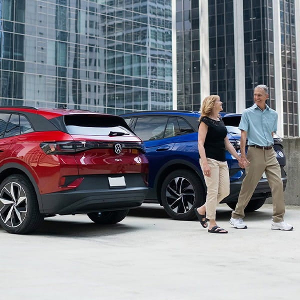A couple walking together past new Volkswagen vehicles in Metro Detroit