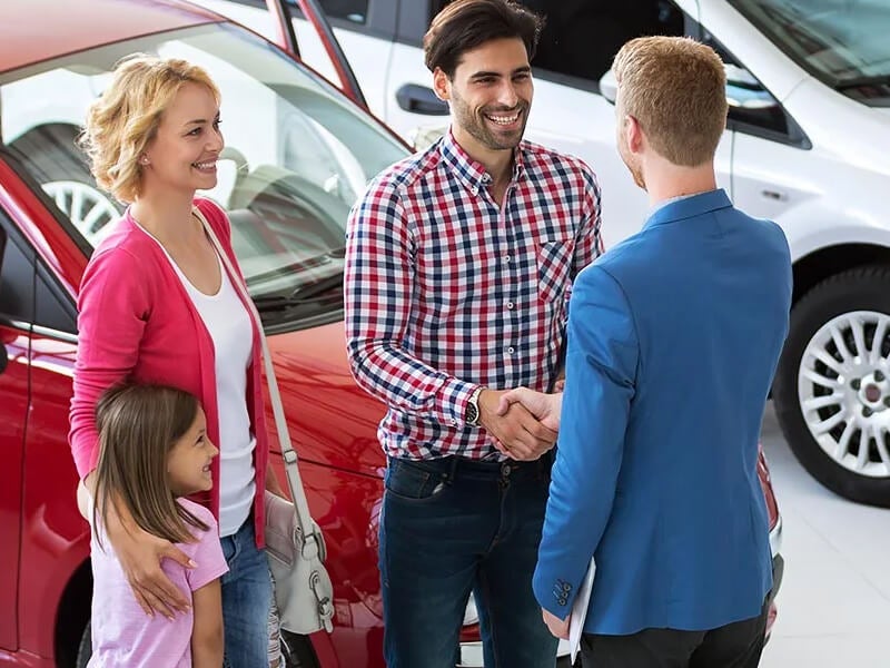 salesman shaking hand with man came with family